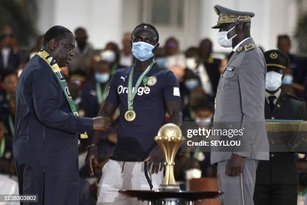 Senegal's President Macky Sall decorates Senegal's forward Sadio Mane during the decoration ceremony near the Palace of the Republic in Dakar on...