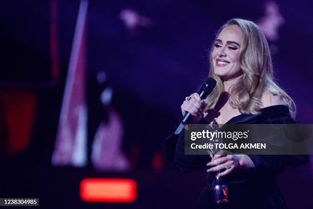 British singer Adele Laurie Blue Adkins aka Adele celebrates after receiving the album of the year award during the BRIT Awards 2022 ceremony and...