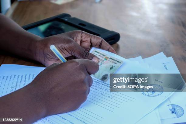 An IEBC agent seen writing on the registration papers during the last day of mass voters registration in Kibera Slums. Due to a lack of ID cards held...