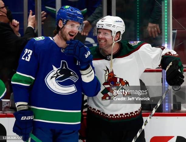 Oliver Ekman-Larsson of the Vancouver Canucks talks with Phil Kessel of the Arizona Coyotes during warmup before their NHL game at Rogers Arena...