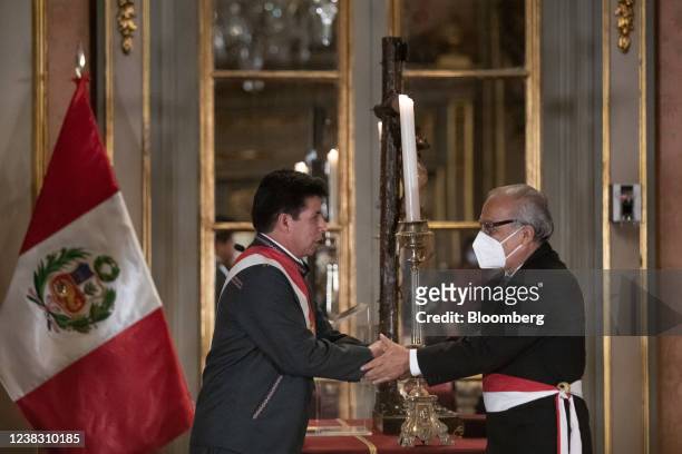 Pedro Castillo, Peru's president, left, shakes hands with Anibal Torres, Peru's new prime minister, during a swearing-in ceremony at the Government...