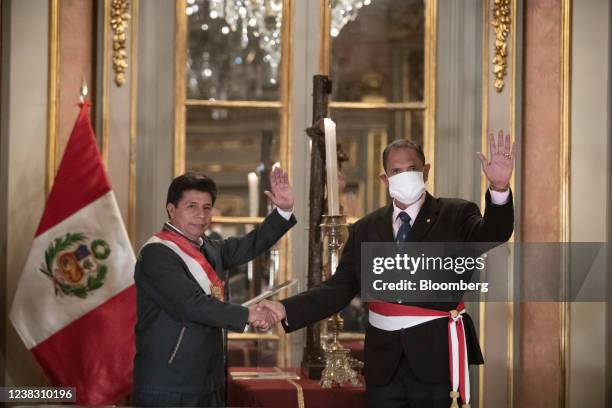 Pedro Castillo, Peru's president, left, shakes hands with Jose Luis Gavidia Arrascue, Peru's new minister of defense, during a swearing-in ceremony...