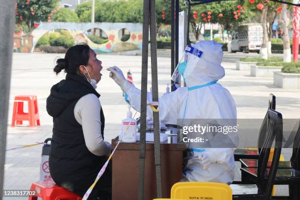 This photo taken on February 7, 2022 shows a resident undergoing a nucleic acid test for the Covid-19 coronavirus in Baise in China's southern...