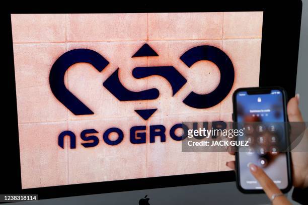 Photographic illustration shows a mobile phone near the NSO Group company logo on February 9, 2022 in the Israeli city of Netanya. - Israel's...