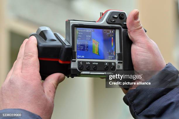 February 2022, Thuringia, Stadtroda: Steffen Kind from the Büro für Energieberatung und Gebäudeanalytik looks at a GDR panel building with an...