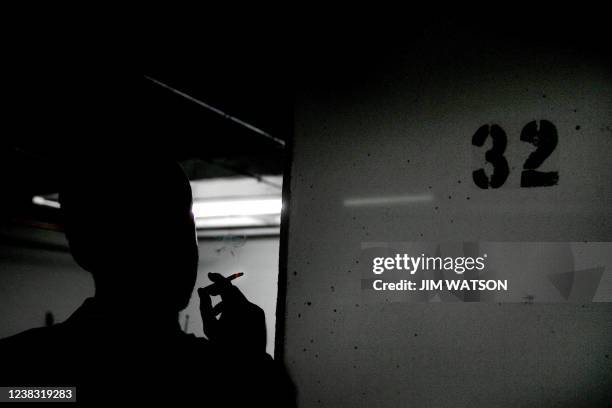 Reporter smokes a cigarette beside Column 32 on the D floor of the garage at 1401 Wilson Blvd 01 July 2005 in Rosslyn, VA, where Washington Post...