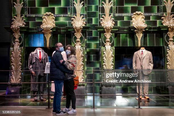 Visiting couple embrace wearing masks in the ministry of magic corridor at Warner Bros studio tour, The Making of Harry Potter on the 27th of...