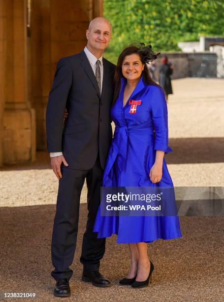 Actress Nina Wadia poses next to her husband Raiomond Mirza, with her OBE following an investiture ceremony at Windsor Castle on February 9, 2022 in...