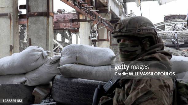 Serviceman of Ukrainian Military Forces stands guard at the destroyed industrial zone in town of Avdiivka on the front-line with Russia-backed...