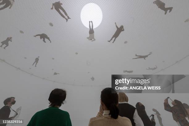 People experience the interactive installation 'Free the Air: How to hear the universe in a spider/web,' during a press preview of the new exhibition...