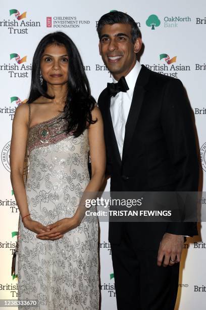 Britain's Chancellor of the Exchequer Rishi Sunak pose with his wife Akshata Murthy for pictures during a reception to celebrate the British Asian...