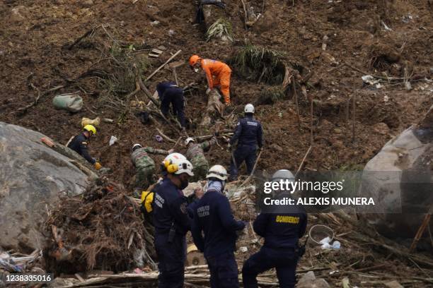 Rescuers search for victims after a landslide caused by heavy rains in Pereira, Risaralda department, Colombia, on February 9, 2022. - At least 14...