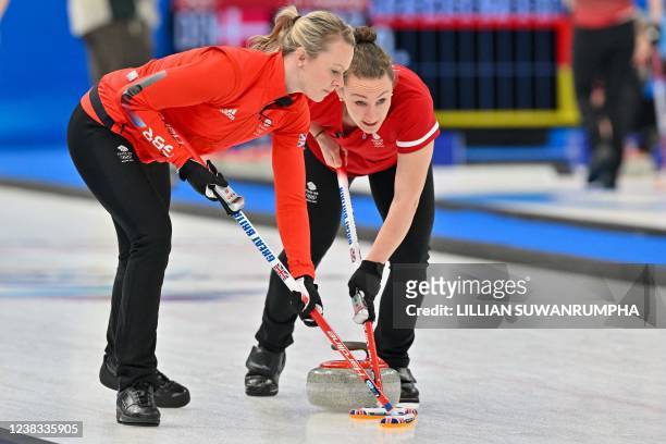 Britain's Jennifer Dodds and Vicky Wright sweep during the women's round robin session 1 game of the Beijing 2022 Winter Olympic Games curling...