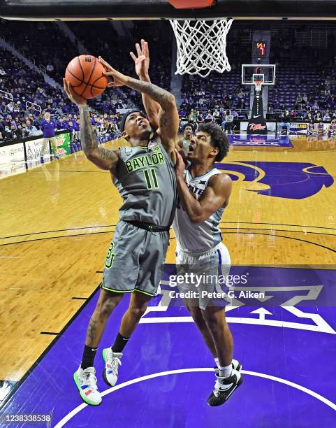 James Akinjo of the Baylor Bears drives and scores against Mark Smith of the Kansas State Wildcats, during the second half at Bramlage Coliseum on...