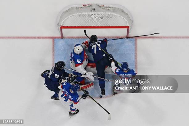 Finland's Leo Komarov falls into the goal of Slovakia during their men's preliminary round group C match of the Beijing 2022 Winter Olympic Games ice...