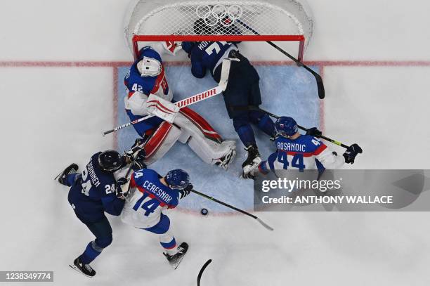 Finland's Leo Komarov falls into the goal of Slovakia during their men's preliminary round group C match of the Beijing 2022 Winter Olympic Games ice...