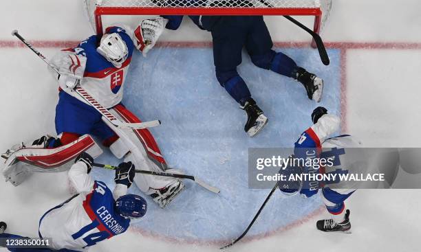 Finland's Leo Komarov lands inside the goal of Slovakia during their men's preliminary round group C match of the Beijing 2022 Winter Olympic Games...