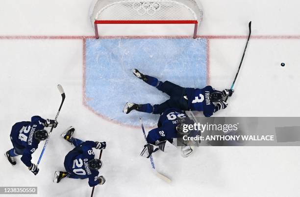 Finland's Niklas Friman defends his goal next to goal tender Harri Sateri during their men's preliminary round group C match of the Beijing 2022...