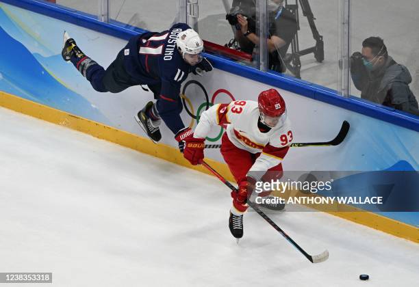 S Kenny Agostino chases China's Zach Yuen during their men's preliminary round group A match of the Beijing 2022 Winter Olympic Games ice hockey...