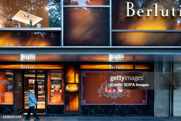 Pedestrian walks past the Italian fashion brand Berluti store in Hong Kong.