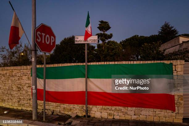 Italian flag placed on the wall on the occasion of the Day of Remembrance of the victims of sinkholes, at Via Martiri delle Foibe in Ruvo di Puglia...