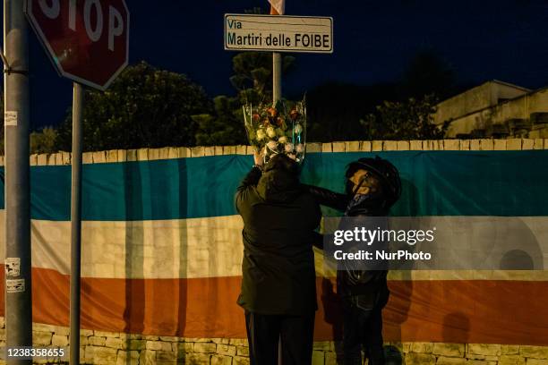 Two participants in the event on the occasion of the Day of Remembrance of the victims of sinkholes lay flowers, at Via Martiri delle Foibe in Ruvo...