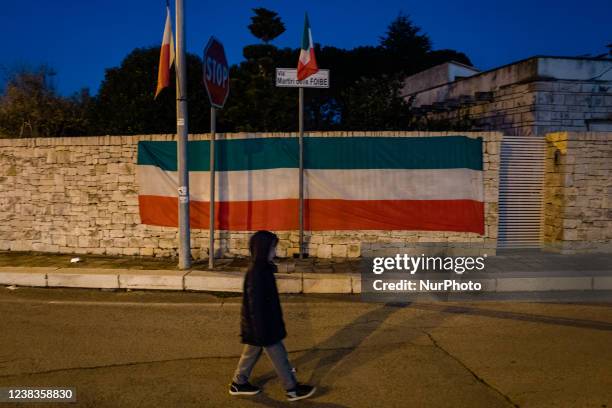 Italian flag placed on the wall on the occasion of the Day of Remembrance of the victims of sinkholes, at Via Martiri delle Foibe in Ruvo di Puglia...