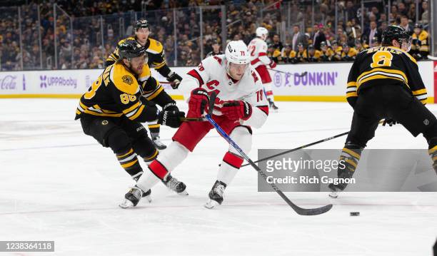 Steven Lorentz of the Carolina Hurricanes battles against David Pastrnak of the Boston Bruins for the puck during the second period at the TD Garden...