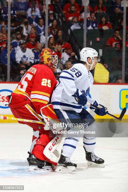 Jacob Markstrom of the Calgary Flames battles through a screen against Michael Bunting of the Toronto Maple Leafs at Scotiabank Saddledome on...