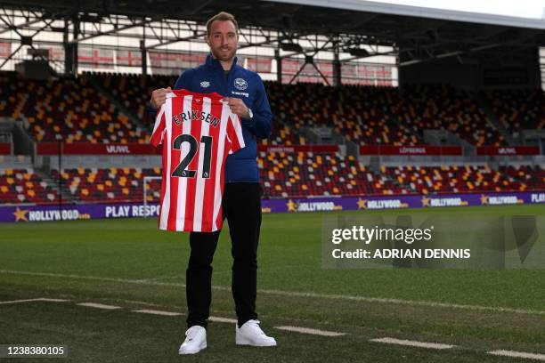 Brentford's Danish midfielder Christian Eriksen holds up a Brentford shirt as he is introduced to members of the media at a photocall inside...