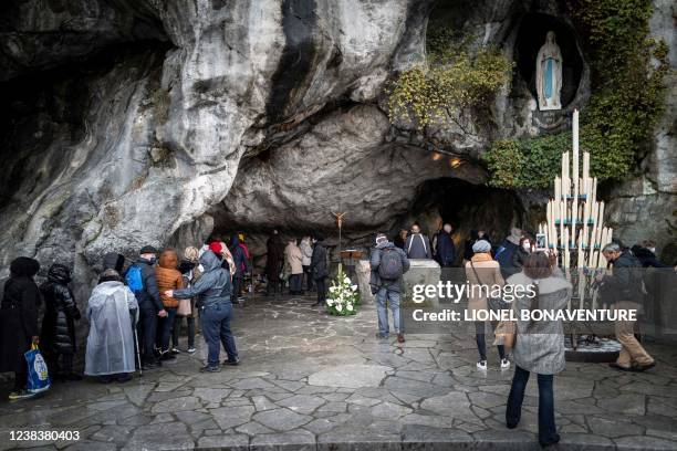 People arrive for the re-opening of Massabielle cave in the Sanctuary of Our Lady of Lourdes in Lourdes, southwestern France, on February 11, 2022. -...