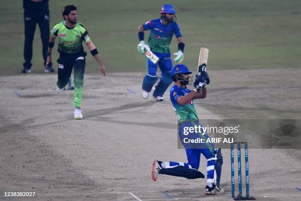 Multan Sultans' Shan Masood plays a shot as Lahore Qalandars' captain Shaheen Shah Afridi during the Pakistan Super League Twenty20 cricket match...