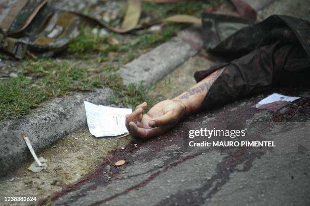 Graphic content / A body lies on a street after a police raid in the neighborhood of Vila Cruzeiro, on Rio de Janeiro's north side, Brazil, on...