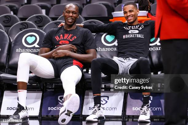 Gorgui Dieng of the Atlanta Hawks laughs with Dejounte Murray of the San Antonio Spurs during warm ups before a game at State Farm Arena on February...