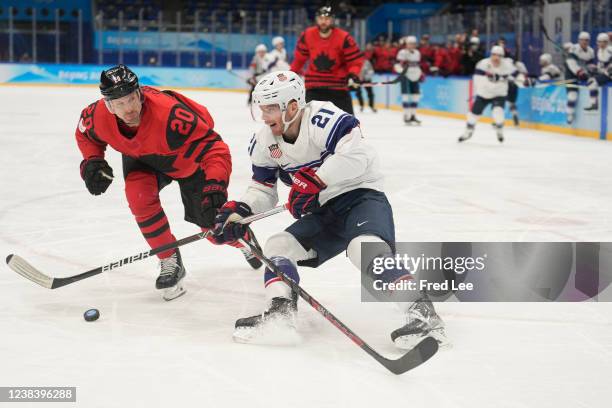 Alex Grant of Team Canada defends Brian O'Neill of Team United States in the second period during the Men's Ice Hockey Preliminary Round Group A...