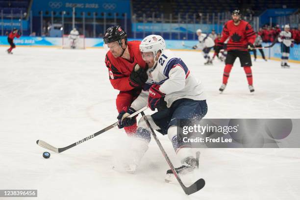 Alex Grant of Team Canada defends Brian O'Neill of Team United States in the second period during the Men's Ice Hockey Preliminary Round Group A...