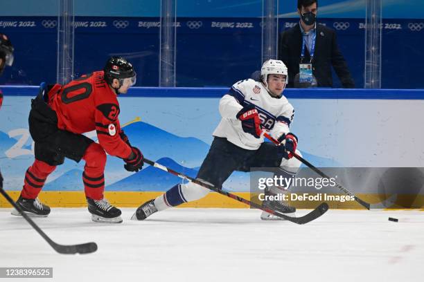 Alex Grant of Canada and Sean Farrell of USA battle for the puck at the men's ice hockey group A preliminary round match between Canada and USA...