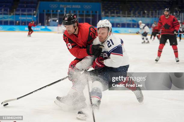 Alex Grant of Team Canada defends Brian O'Neill of Team United States in the second period during the Men's Ice Hockey Preliminary Round Group A...