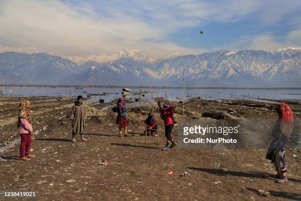 Kashmiri girls play cricket on the banks of Wular Lake in Bandipora, Jammu and Kashmir, India on 12 Feburary 2022.