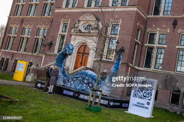 Two women are seen talking while looking at the recycled jeans sculpture called Messy. During the celebration of the COP26 in Glasgow, WaterBear...