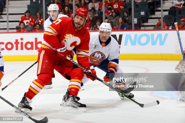 Milan Lucic of the Calgary Flames skates against Andy Greene of the New York Islanders at Scotiabank Saddledome on February 12, 2022 in Calgary,...