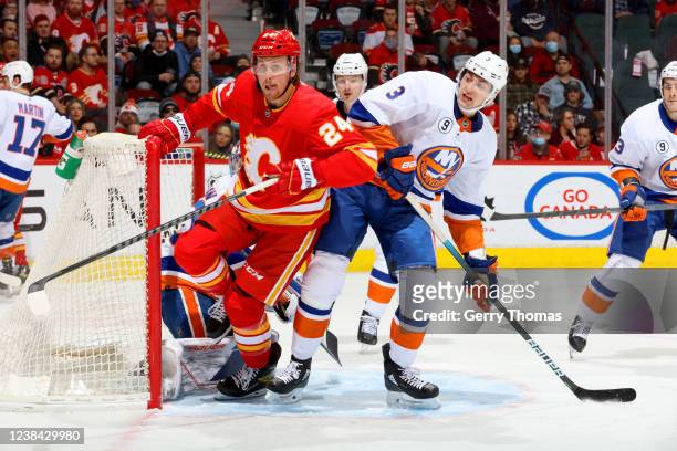 Brett Ritchie of the Calgary Flames skates against Adam Pelech of the New York Islanders at Scotiabank Saddledome on February 12, 2022 in Calgary,...