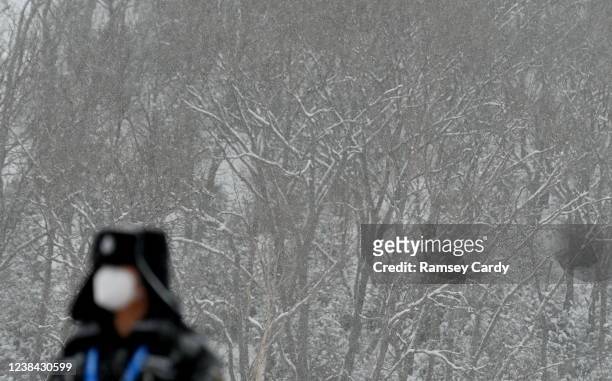 Yanqing , China - 13 February 2022; A member of security watches on as snow falls during a break in the Men's Giant Slalom event on day nine of the...