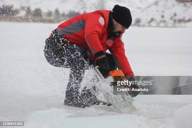 Staff uses ice saw to open an enter as Record holder freediver Birgul Erken attends a training at frozen Lake Todurge in Zara district of Sivas,...