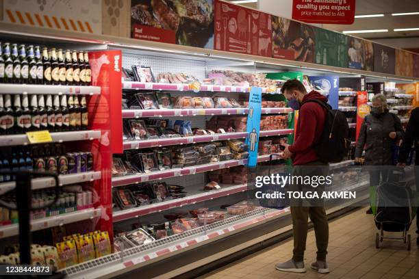 Customer shops for meat at a Sainsbury's supermarket in Walthamstow, east London on February 13, 2022. - UK annual inflation struck 5.4 percent in...