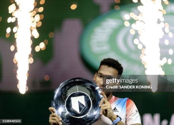 Canada's Felix Auger-Aliassime poses with the trophy as he celebrates after victory over Greece's Stefanos Tsitsipas in theie men's singles match on...