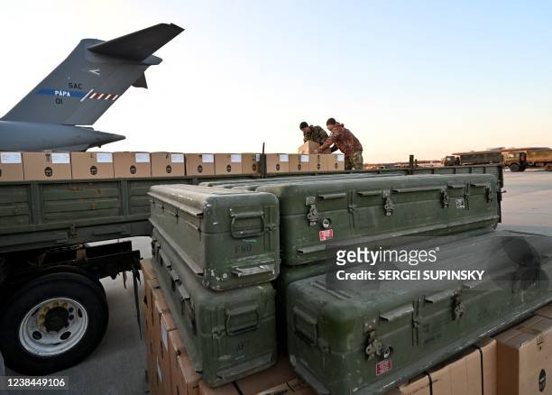 Servicemen of Ukrainian Military Forces load a flat bed truck with boxes as US made FIM-92 Stinger missiles , a man-portable air-defence system ,...
