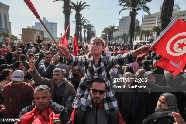 Young girl on a demonstrators shoulders, shouts slogans as she waves Tunisian flags during a demonstration held at the initiative of Citizens Against...
