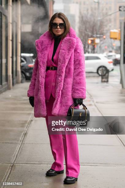 Natalia Levsina wears a faux fur coat by Apparis, pants by Ralph Lauren, top by Ralph Lauren, handbag and belt by YSL, sunglasses by Dior and boots...