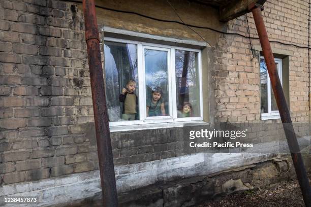 Three of the Mazur children look out their apartment window. Igor and Eugenia Mazur, the parents of 5 children all under 8 years of age, live...